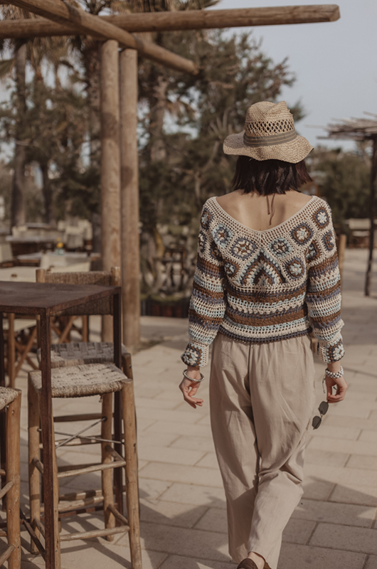 Back view of sunset-tone granny‑square crochet sweater showing square motif pattern and relaxed boxy fit