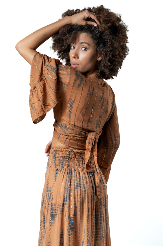 Rear view of the same outfit, showing the tie detail at the back of the top and the smocked waistband of the skirt.