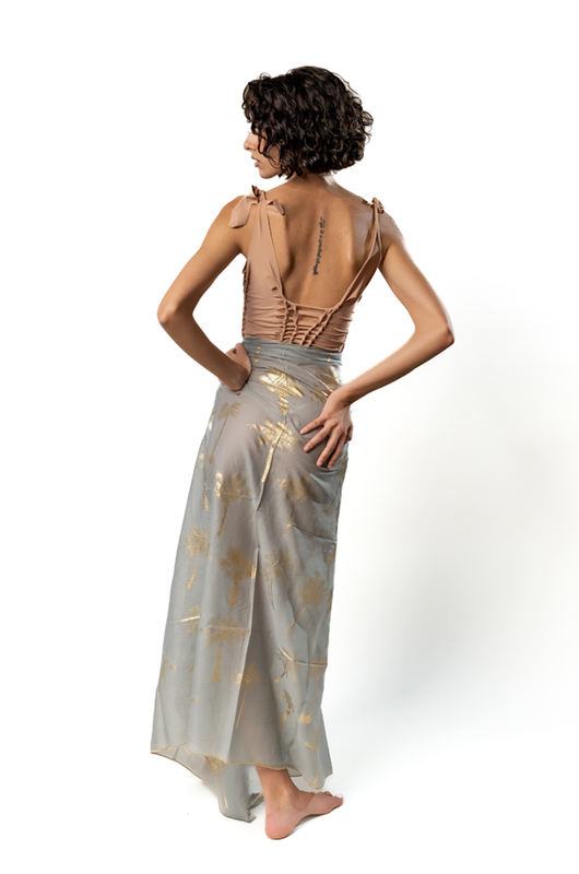 Back view of model in long pareo with tassel details and palm print.