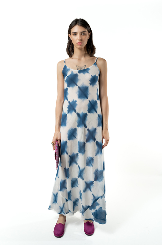 Model wearing a bias-cut maxi dress with spaghetti straps, featuring a blue tie-dye pattern, front view.