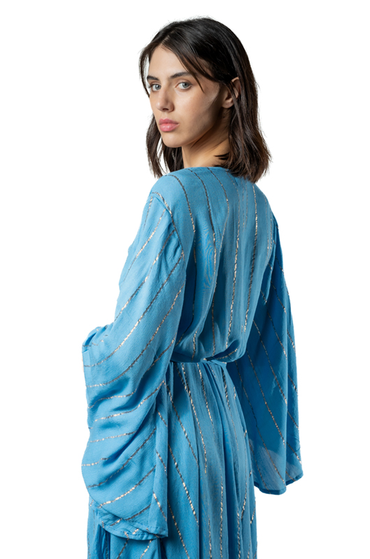 Close-up from the back of a woman wearing a sky-blue dress with silver stripes, focusing on the draped sleeves and tie at the waist.