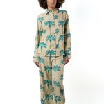 A model wearing a teal palm tree print matching set, standing against a plain white background.