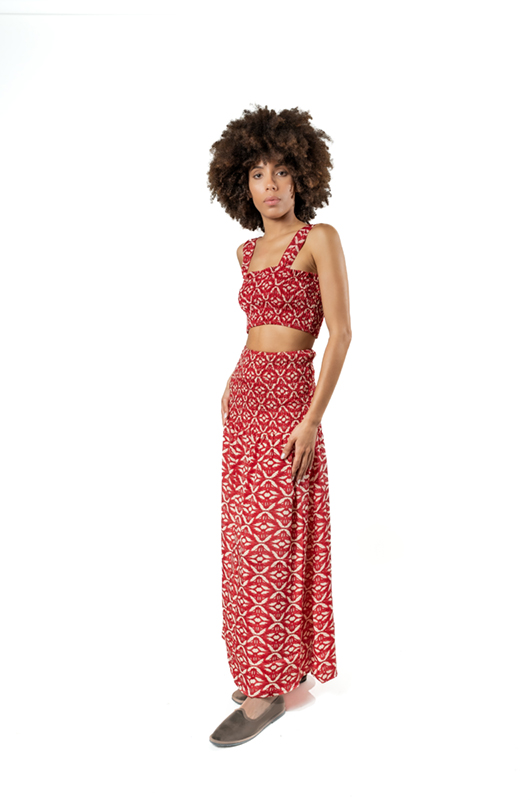 "Model wearing a red bohemian crop top and matching maxi skirt with ethnic patterns – front side pose"