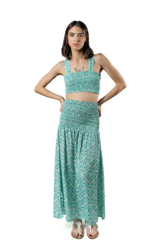 “Back view of fitted crochet skirt with tribal-inspired pattern, midi length over evening beachwear
