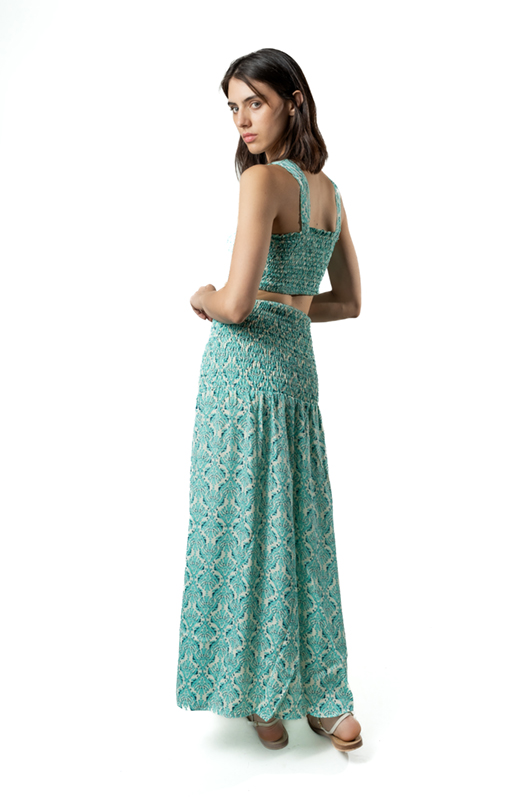 “Back view of fitted skirt with tribal-inspired pattern, midi length over evening beachwear