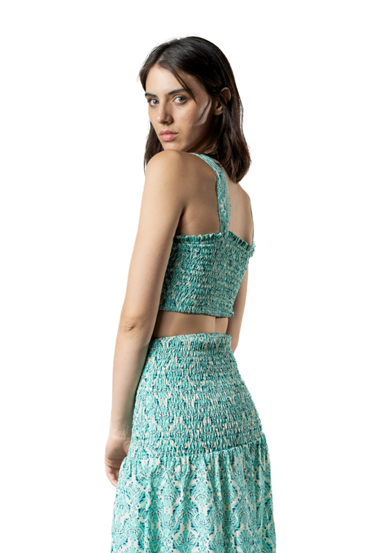 “Back view of fitted skirt with tribal-inspired pattern, midi length over evening beachwear