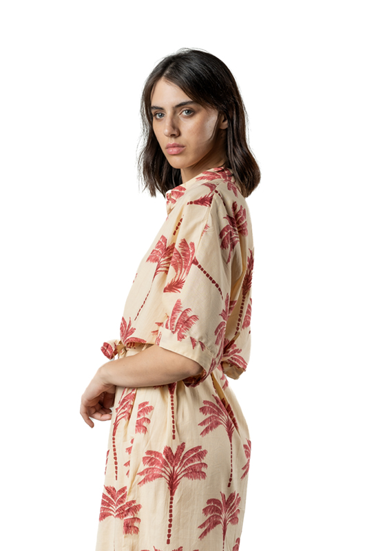 Close-up side view of the beige dress with red palm tree print, focusing on the upper half of the model.