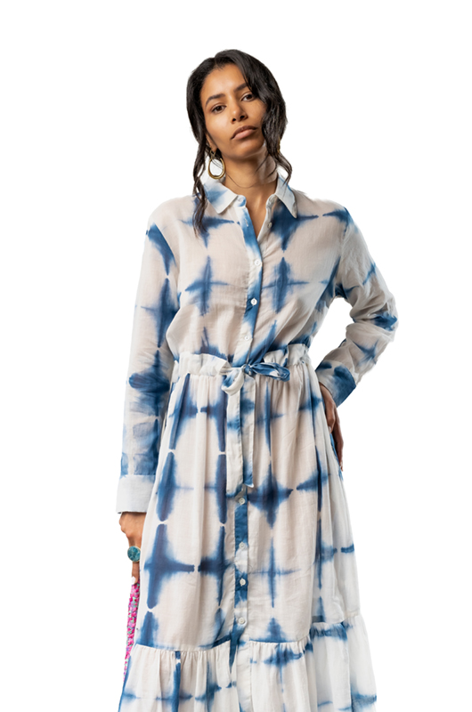 Close-up view of a woman in a blue tie-dye button-down dress with a fabric belt tied at the waist.