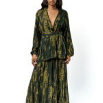 "Front view of a woman wearing a dark green two-piece set with a gold abstract print, featuring a deep V-neck wrap kimono-style top with a belt and a long matching skirt."