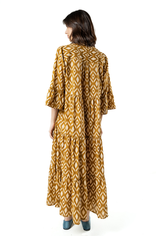 Back view of mustard yellow boho maxi dress with tiered skirt and wide sleeves, geometric patterned fabric