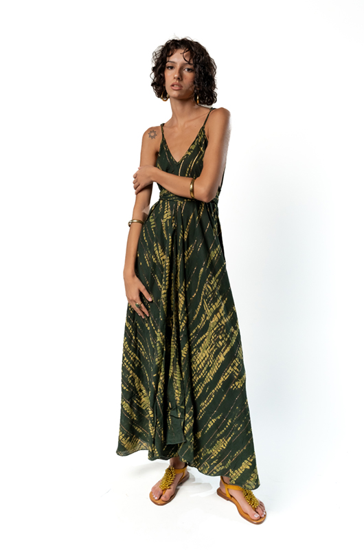 "Model in a green tie-dye maxi dress with a V-neckline, standing with arms crossed, showcasing a relaxed bohemian style."