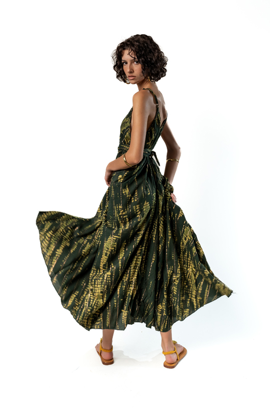 "Model twirling in a green tie-dye maxi dress, highlighting the flowing movement of the fabric."