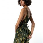 "Close-up of the back of a green tie-dye maxi dress with thin straps and a tied waist detail."