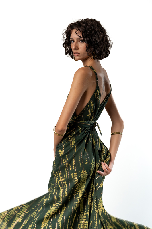 "Close-up of the back of a green tie-dye maxi dress with thin straps and a tied waist detail."