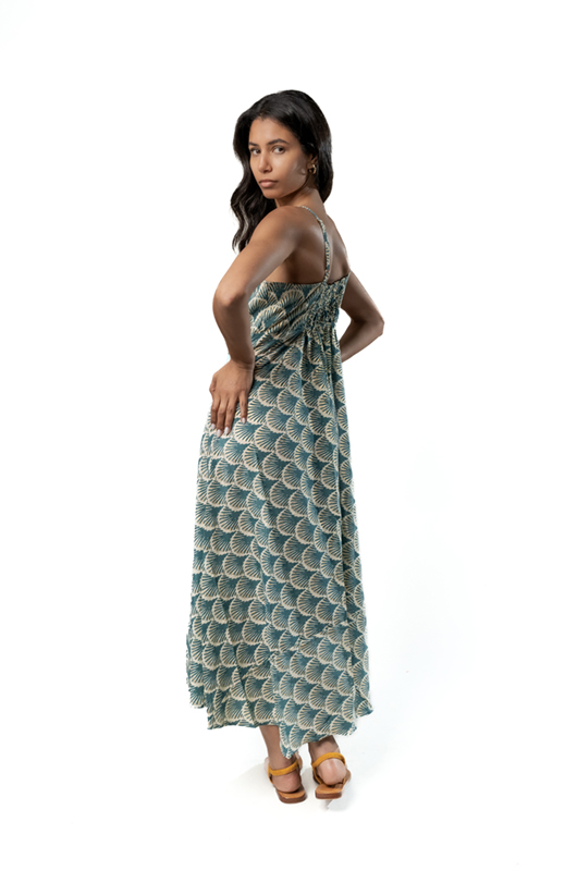 Angled back view of a teal and cream fan print midi dress with smocked back and flowy silhouette.