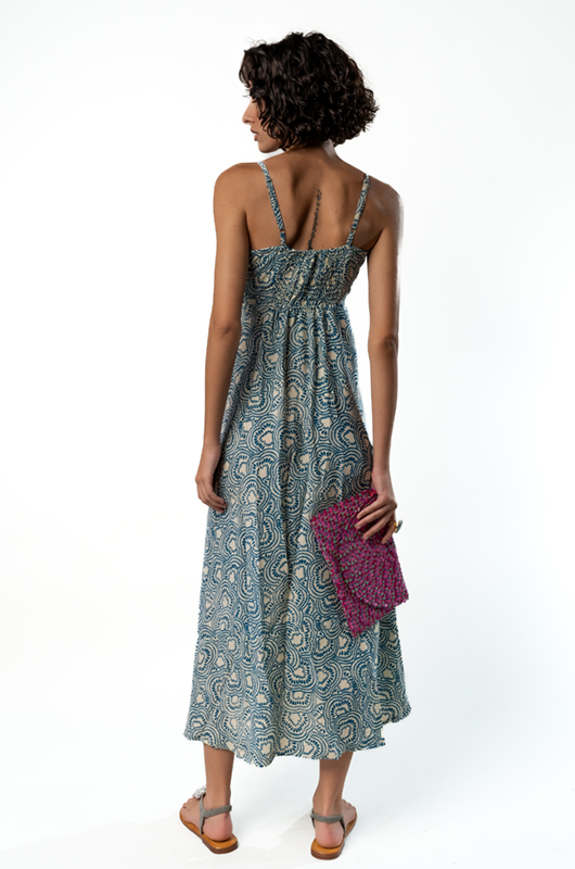 Back view of a blue and cream paisley midi dress with thin straps and gathered back detail.