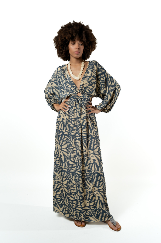 "Front view of a woman posing in a floor-length grey printed dress with a plunging neckline and long puff sleeves."