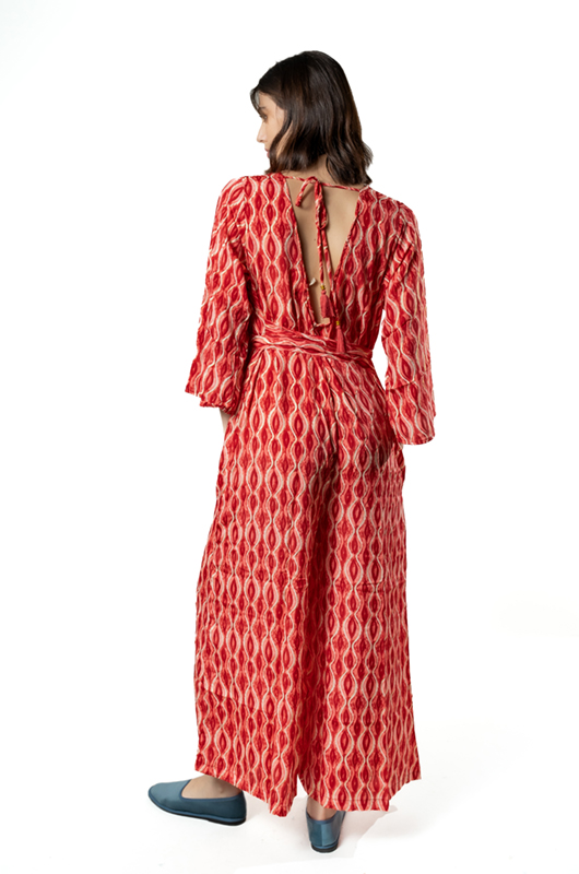 Back view of a red curves print jumpsuit with an open tie-back and a matching waist tie.